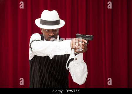 Joueur bien habillé dans un costume rétro braquer une arme Banque D'Images