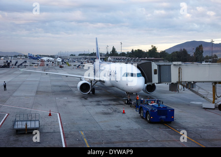 LAN Airlines avion avec tirer sur le stand Comodoro Arturo Merino Benítez de l'Aéroport International Santiago Chili tourné à travers la vitre Banque D'Images