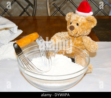 Teddy bear wearing santa hat avec bol de pâte à tarte en devenir Banque D'Images