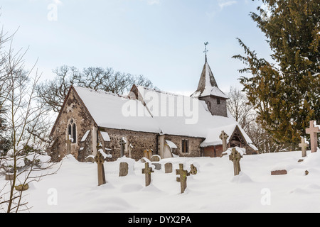 L'église et de l'église de St Nicholas, Pyrford, Surrey, UK dans la neige en hiver Banque D'Images