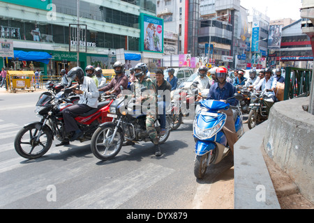 Une scène de rue montrant les gens en moto par le Métro sur MG (Mahatma Gandhi) Road, à Bangalore, Karnataka, Inde Banque D'Images