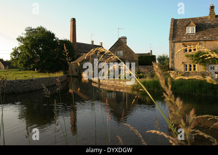 Vue d'ensemble des voies navigables jusqu'à la période de réflexion calme cottages en pierre de faible ensoleillement d'or bas Banque D'Images