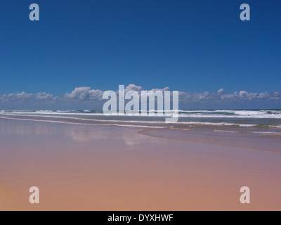 Low angle view dans une plage à marée basse avec les vagues de surf parfait ciel bleu ensoleillé. jour avec des nuages bas Banque D'Images