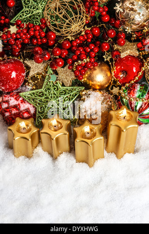 La décoration de l'avent fête de Noël avec des bougies, des guirlandes d'or, arbre de Noël, branches et fruits rouges. Banque D'Images