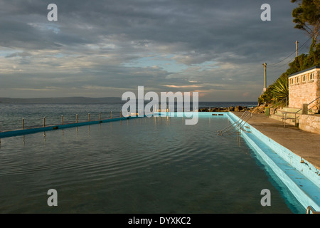 Bassin de marée océan construit en mer naturelle-rocks. photo sur encore jour avec des nuages de tempête et Golden Sunlight sur piscine et des capacités Banque D'Images