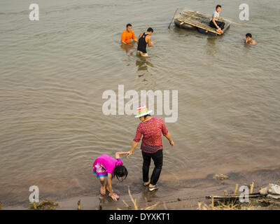 22 avril 2014 - Chiang Saen, Chiang Rai, Thaïlande - Les Thaïlandais jouent dans le Mékong, du côté thaïlandais de la rivière à Chiang Saen, Thaïlande. La province de Chiang Rai dans le nord de la Thaïlande est au milieu de la saison sèche. Il n'y a pas eu de pluies importantes en mois et le niveau de la rivière du Mékong est en baisse. Comme le niveau de la rivière baisse, les conducteurs de bateaux beach leurs bateaux pour effectuer les travaux d'entretien, et certains des plus gros bateaux cargo chinois ne peut pas aller en aval au sud de Chiang Saen parce qu'îles et bancs de forme dans le voyage Carte du Mékong. Laissez les agriculteurs de leurs champs en jachère ou gr Banque D'Images