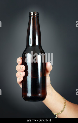 Young woman's hand holding une bouteille de bière Banque D'Images