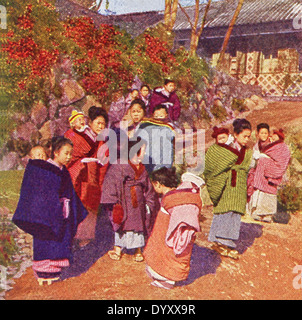 Cette scène au Japon remonte à 1909. Il montre des bébés sur les bébés de leurs grandes sœurs. Banque D'Images
