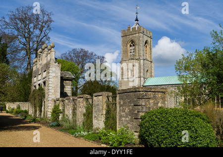 Pierre ornée dans le parc du château d'Ashby Gardens, clocher de l'église en arrière-plan Banque D'Images