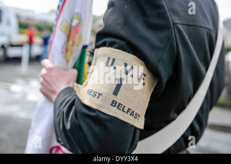 Un homme porte un brassard Ulster Volunteer Force, et carry un drapeau de l'université virtuelle Banque D'Images