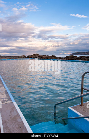 Bassin de marée océan construit dans le sea sunset précoce. calme l'eau de piscine, reflétant les couleurs du ciel. L'Australie Banque D'Images