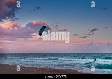 Seule vague kitesurf sur aqua bleu océan dans les vagues près de la côte avec lavande et spectaculaire coucher du soleil bleu Australie Banque D'Images