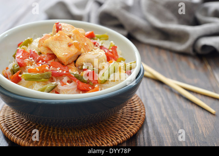 Les nouilles de riz avec le poulet et les légumes dans un bol closeup Banque D'Images