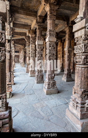 New Delhi, Inde. Colonnes hindoues incorporés dans la Quwwat Ul-Islam, première mosquée construite en Inde, Qutb Minar Complex. Banque D'Images