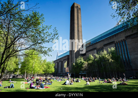Les gens se détendre dans le parc en face de la Tate Modern Art Gallery de Londres, Royaume-Uni Banque D'Images