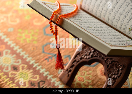 Perles de prière islamique suspendu à un Coran ouvert Banque D'Images