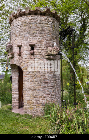Westonbury Mill Water Gardens, Pembridge, Herefordshire. La tour en pierre, avec gargouilles crachant Banque D'Images