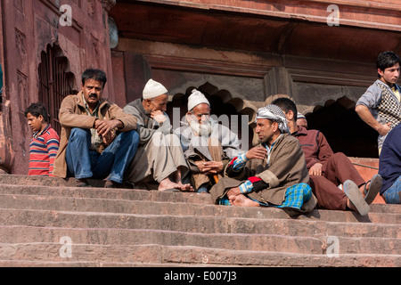 New Delhi, Inde. Les hommes musulmans assis sur les marches de la Jama Masjid (mosquée du vendredi), En attente d'un temps de prière. Banque D'Images