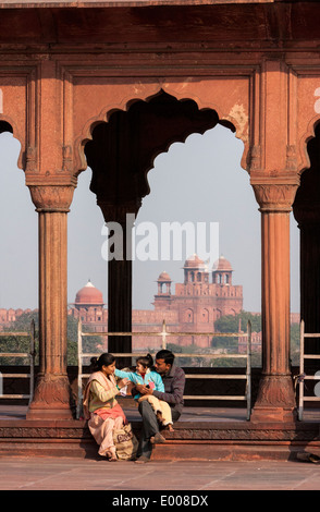 New Delhi, Inde. Famille musulmane à la Jama Masjid (mosquée du vendredi). Fort rouge en arrière-plan. Banque D'Images