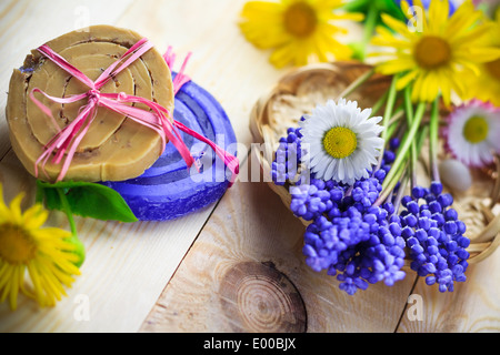 Savon artisanal et de fleurs sur une table en bois Banque D'Images