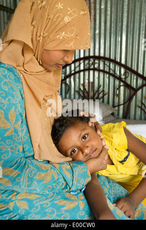 Dhaka, Bangladesh. Feb 27, 2014. Le 27 février 2014, Dhaka, Bangladesh - Nahar Akhter' passe quelques minutes avec son fils de cinq ans Safwan avant de retourner à l'usine de vêtements mode de marque peu après sa pause déjeuner. © David Snyder/ZUMAPRESS.com/Alamy Live News Banque D'Images