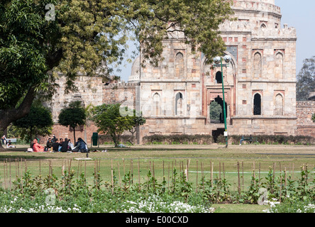 New Delhi, Inde. Les amis de savourer un pique-nique samedi et Conversation au Lodi Gardens. Bara Gumbad en arrière-plan. Banque D'Images