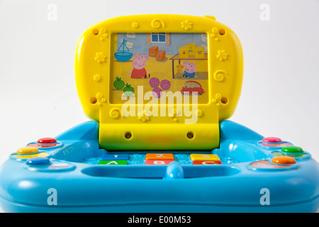 Le savez bien marque Peppa Pig sur un tout-petit enfant portable bleu et jaune qui joue de la musique, s'allume et a des jeux sur elle. Banque D'Images