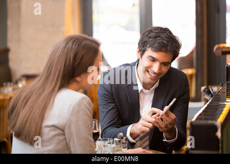 Man woman using cell phone bar café Banque D'Images