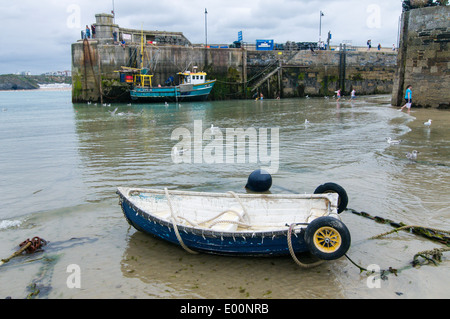 Petit bateau à rames et un bateau de pêche amarré à l'intérieur du port de Newquay. Banque D'Images