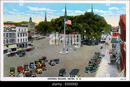 Cette photographie des années 1920 montre Central Square à Keene, New Hampshire, capturant le charme historique du centre-ville. L'image présente des voitures anciennes, le quartier animé des affaires et un mât de drapeau, offrant un aperçu de la vie quotidienne au début du XXe siècle. Il met en valeur les styles architecturaux et l'atmosphère communautaire de l'époque. Banque D'Images