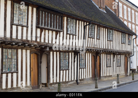 Dame à la recherche d'une fenêtre à partir de la 15ème siècle à pans de bois du noir et blanc à l'Église hospices Road, Stratford-upon-Avon Banque D'Images