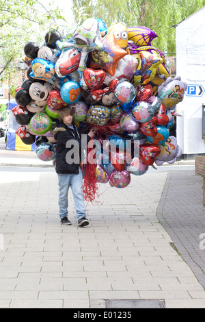 Un homme marche à travers d'un gros bouquet de ballons bleu Banque D'Images