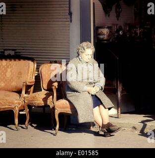 Aîné d'une femme assise sur un fauteuil à Porte de Clignancourt à Paris, 1967 Banque D'Images