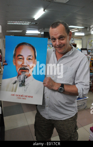 Visiteur occidental détient 3D affiche de héros révolutionnaire vietnamien et président Ho Chi Minh à Hanoi, Vietnam Banque D'Images