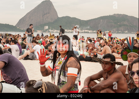 Le Sommet des peuples à la Conférence des Nations Unies sur le développement durable (Rio +20), Rio de Janeiro, Brésil. Mayalu Kayapo Txukaramae montre une main peinte rouge contre la construction de barrages en Amazonie, au cours de la démonstration des bannières sur la plage avec le pain de sucre derrière. 19 juin 2012. Photo © Sue Cunningham. Banque D'Images