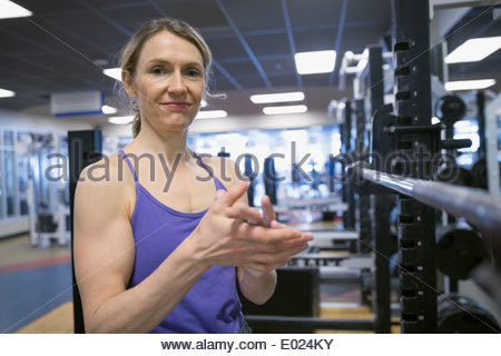 Portrait of smiling woman le levage de poids at gym
