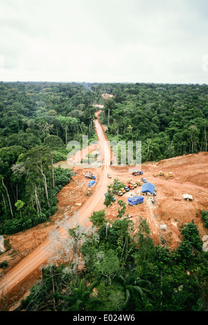 L'Amazonas, Brésil. Vue aérienne de la forêt tropicale à son effacement à l'exploration pétrolière, une nouvelle route avec une file de camions et d'un nouveau pont, des bulldozers. Amazon. Banque D'Images