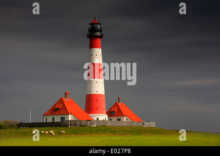 Photo de la rouge et blanc à rayures westerheversand phare avec Ciel et nuages, tempête eiderstedt péninsule, Allemagne Banque D'Images