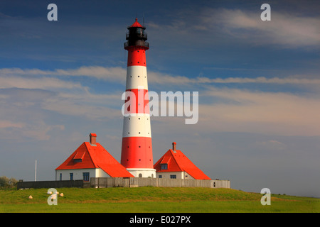 Photo de la rouge et blanc à rayures westerheversand phare avec Ciel et nuages, tempête eiderstedt péninsule, Allemagne Banque D'Images