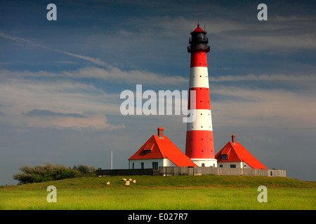 Photo de la rouge et blanc à rayures westerheversand phare avec Ciel et nuages, tempête eiderstedt péninsule, Allemagne Banque D'Images