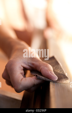 Mains d'une femme avec du papier de bricolage faire travailler sur d'en bois Banque D'Images