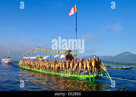 Leg-rameurs d'avancer en tirant sur la barge royale à travers le lac Inle pendant le festival Banque D'Images