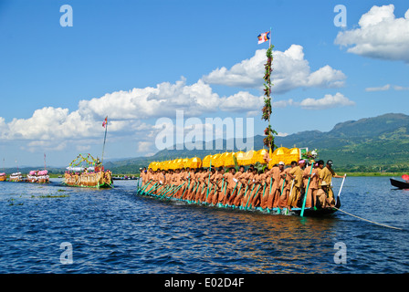 Leg-rameurs d'avancer en tirant sur la barge royale à travers le lac Inle pendant le festival Banque D'Images