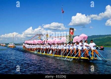 Leg-rameurs d'avancer en tirant sur la barge royale à travers le lac Inle pendant le festival. Banque D'Images