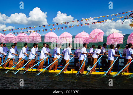 Leg-rameurs d'avancer en tirant sur la barge royale à travers le lac Inle pendant le festival Banque D'Images