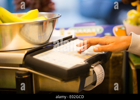 Les jeunes femmes close-up fruits main bill scales Banque D'Images