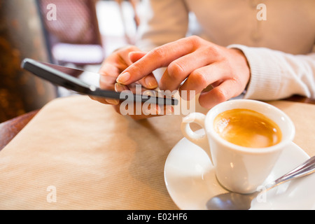 Smart phone femelle sms mail bar café Banque D'Images