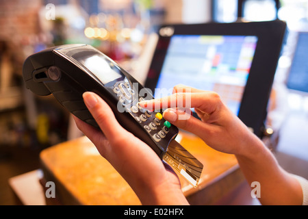 Paiement femelle close-up shop lecteur électronique carte plastique Banque D'Images