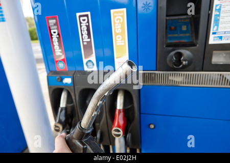 Man holding buse de ravitaillement au gaz naturel Pétrole et biocarburants diesel à grande vitesse les pompes diesel à une station service d'Irlande Banque D'Images