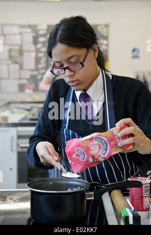 Les élèves / étudiants au cours de la cuisson une classe à leur école Midlands Banque D'Images